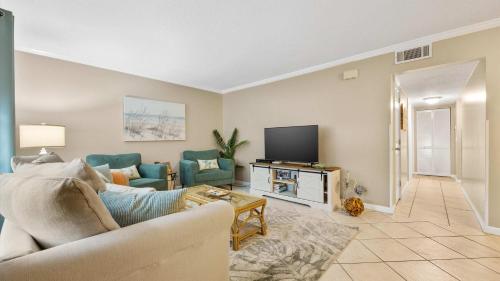 a living room with a couch and a tv at Coastal Clipper - Charming 2 BDR Walk to Beach in St. Augustine