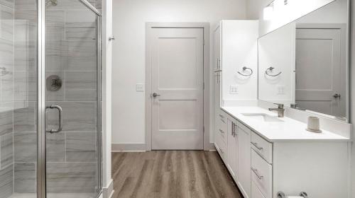 a white bathroom with a shower and a sink at Landing at The Gallery - West Huntsville in Huntsville