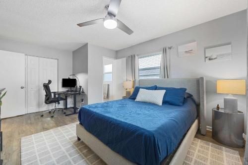 a bedroom with a blue bed and a desk at Casa Playa - Private Home for 6 in St. Augustine