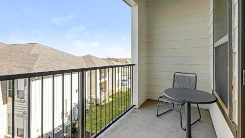 a balcony with a table and a chair at Landing at The Flats at Shadowglen - Manor in Manor