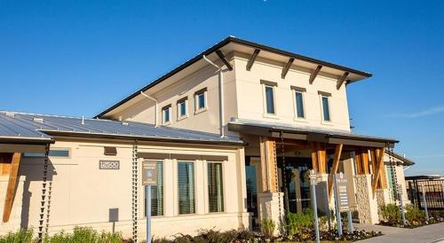 a white house with a black roof at Landing at The Flats at Shadowglen - Manor in Manor