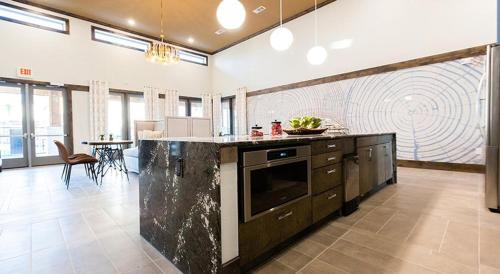 a large kitchen with a large island in a room at Landing at The Flats at Shadowglen - Manor in Manor