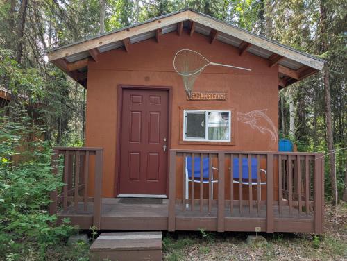 a tiny house with two chairs on a porch at Sven's Basecamp Hostel in Fairbanks