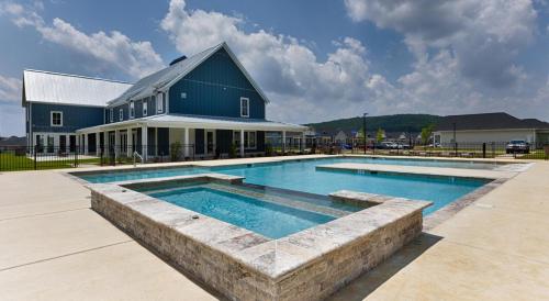 a house with a swimming pool in front of a building at Landing Beautiful 1BD Clubhouse Pool in Owens Cross Roads
