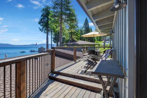 eine Terrasse mit einer Bank und einem Sonnenschirm auf einem Haus in der Unterkunft Waters Edge Jewel with Lake Views - HOA Access in Tahoma