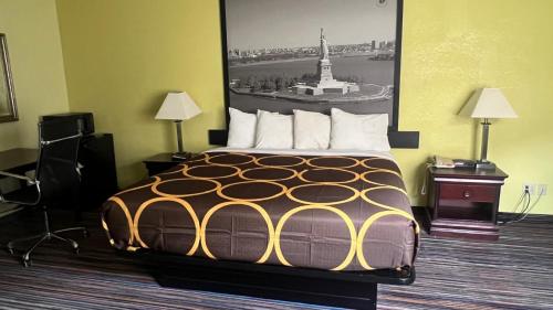 a hotel room with a bed with a picture on the wall at Super 8 by Wyndham Albany in Albany