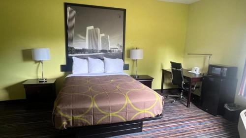 a hotel room with a bed and a desk at Super 8 by Wyndham Albany in Albany
