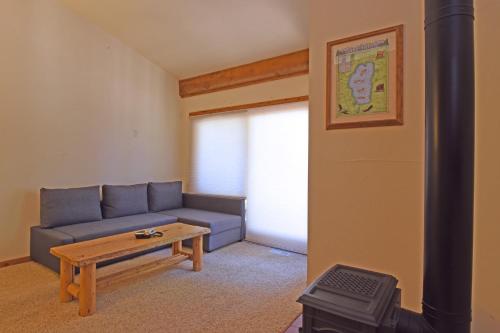 ein Wohnzimmer mit einem blauen Sofa und einem Tisch in der Unterkunft A Golden Getaway Pool Hot Tub Tennis & More in Truckee