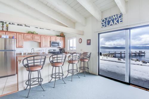 a kitchen with a bar with stools and a view of the ocean at Waters Edge Vista - HOA Pool & Pier Access in Tahoma