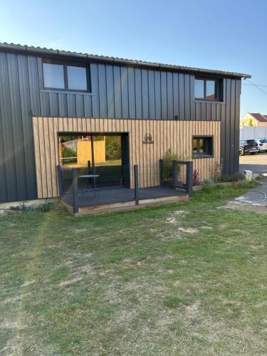 a house with a deck in front of it at Le Hangar - Studio esprit industriel in Pont-Rémy