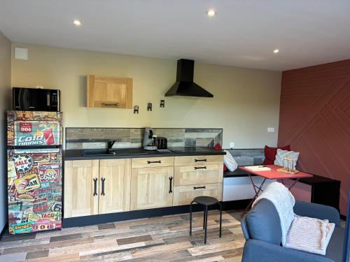 a kitchen with a refrigerator and a table in a room at Le Hangar - Studio esprit industriel in Pont-Rémy