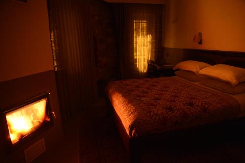 a dark room with a bed and a fireplace at Ayasoluk Hotel & Restaurant in Selcuk