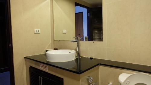 a bathroom with a sink and a mirror at Grand Business Inn in Bangkok