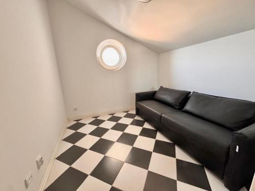 a black couch in a room with a checkered floor at Kumbor sunny port with shared pool in Kumbor