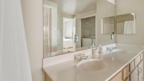 a bathroom with two sinks and a large mirror at Landing at Settlers Ranch - Pasadena in Houston
