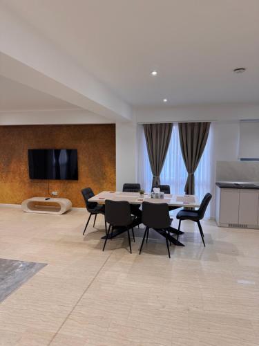 ein Esszimmer mit einem Tisch und schwarzen Stühlen in der Unterkunft Eroilor Apartments in Curtea de Argeş