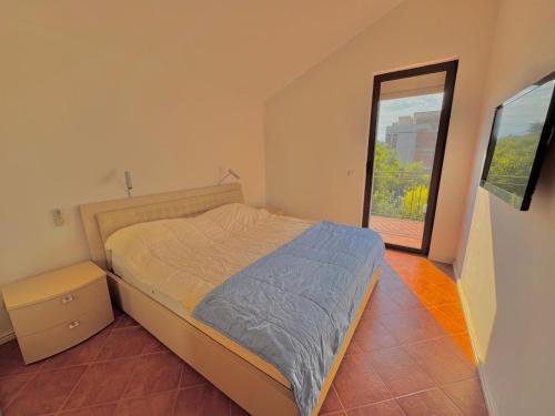 a bedroom with a bed and a large window at Kumbor sunny port with shared pool in Kumbor