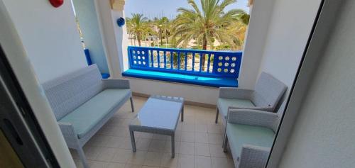 a balcony with chairs and a bench and palm trees at Marina Retreat in Hammamet