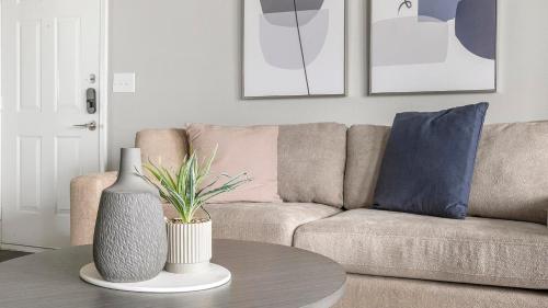 a living room with a couch and a table with a vase at Landing at Residences at River Park West - Richmond in Richmond