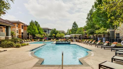 a swimming pool with lounge chairs in a courtyard at Landing at Residences at River Park West - Richmond in Richmond