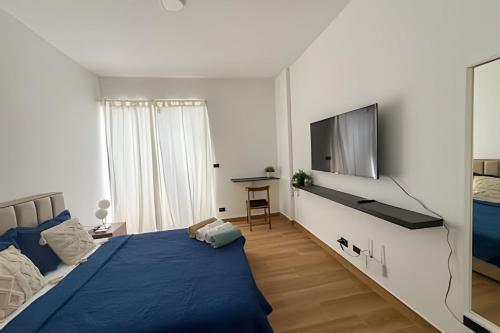 ein Schlafzimmer mit einem Bett und einem Flachbildfernseher in der Unterkunft Estudios en el corazón de Punta Cana in Punta Cana