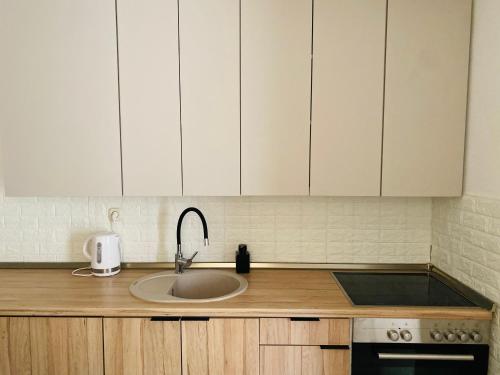 a kitchen with a sink and white cabinets at Farah Apartment in Mostar