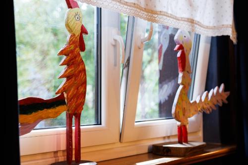 two wooden roosters sitting on a window sill at Willa pod Jemiołą in Wisła