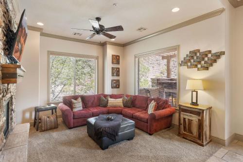 a living room with a red couch and a ceiling fan at Red Cliffs - Scenic Tranquility in Washington
