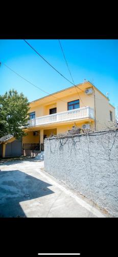 a yellow building with a fence in front of it at Villa 59 in Shkodër