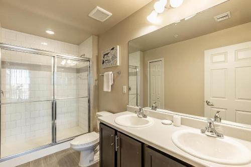 a bathroom with two sinks and a shower and a toilet at Landing Fort Myers near Heritage Palms in Fort Myers