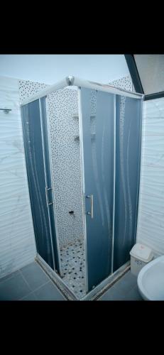 a shower with a glass door in a bathroom at Villa 59 in Shkodër