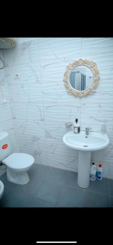 a bathroom with a sink and a toilet and a mirror at Villa 59 in Shkodër