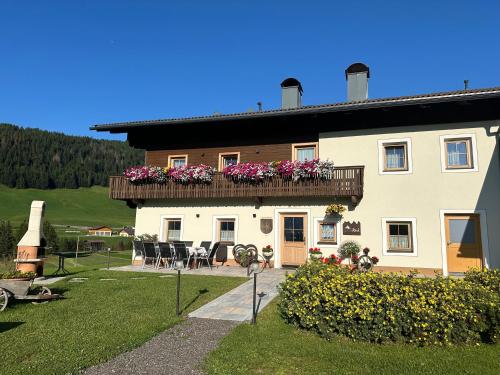 a house with a balcony with flowers on it at Ferienhaus Köck in Kartitsch
