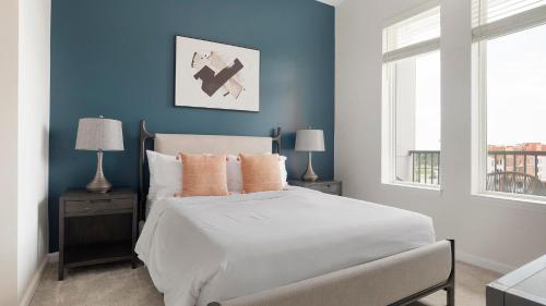 a bedroom with a bed with blue walls and two lamps at Landing Incredible 1BD Pool Gym in Orlando