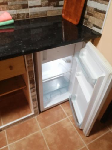 a small refrigerator with its door open in a kitchen at Casa ecologica, autosuficiente con off grid en Lomo Blanco, dentro de una casa rodeada de naturaleza in San Juan de la Rambla