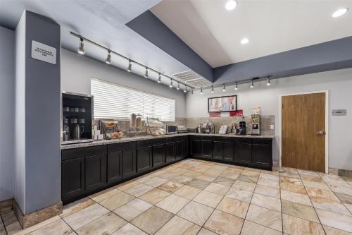 eine große Küche mit schwarzen Schränken und einer Theke in der Unterkunft Best Western Plus Sand Bass Inn and Suites in Madill