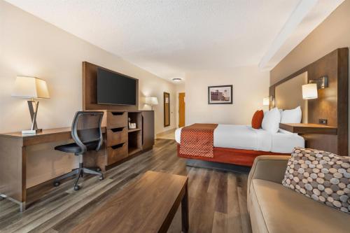 a hotel room with a bed and a desk at Best Western Smiths Falls Hotel in Smiths Falls