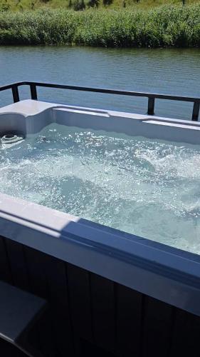 a hot tub on a boat in a body of water at Noce na Wiśle - tylko 15 min od Gdanska in Błotnik