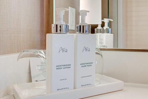 a bathroom with three bottles of soap and a sink at Luxurious Vdara High Rise Room, City Skyline Views, King Bed, Free Valet in Las Vegas