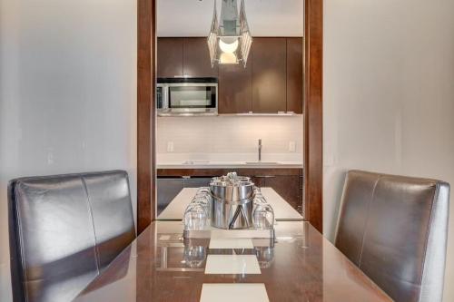 a kitchen with a glass table and two chairs at Luxurious Vdara High Rise Room, City Skyline Views, King Bed, Free Valet in Las Vegas