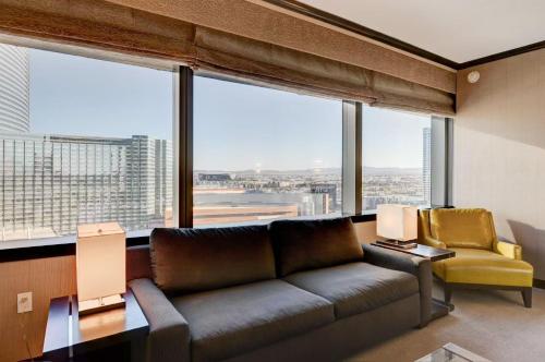 a living room with a couch and a large window at Luxurious Vdara High Rise Room, City Skyline Views, King Bed, Free Valet in Las Vegas