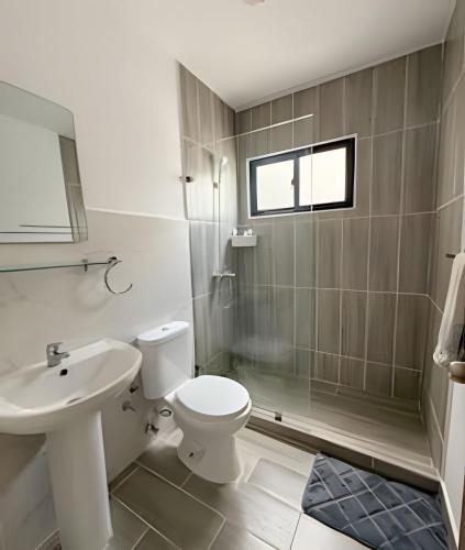 a bathroom with a toilet and a shower and a sink at Epic Punta Cana in Punta Cana