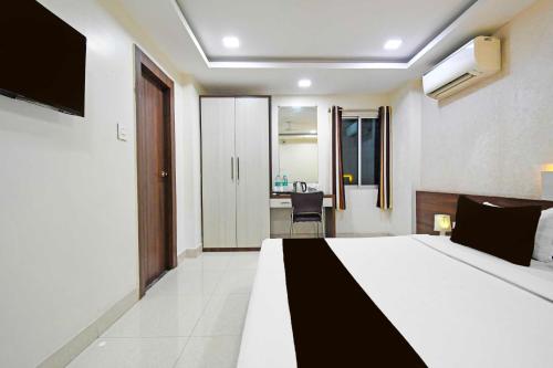 a bedroom with a bed and a desk in a room at Collection O Sahayogi Near Big Bazaar in Dhanbād