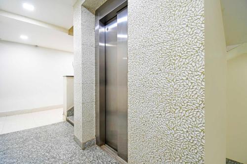 a elevator in a building with a wall of glass at Collection O Sahayogi Near Big Bazaar in Dhanbād