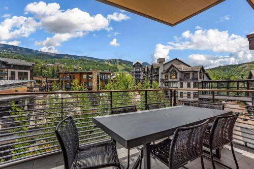 a table and chairs on a balcony with a view at One Snowmass West 603 by Snowmass Mountain Lodging in Snowmass
