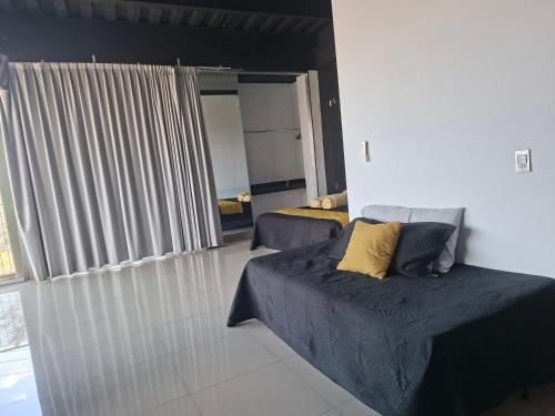 a living room with two beds and a couch at Suites La Gloria Alojamiento independiente in Tepatitlán de Morelos