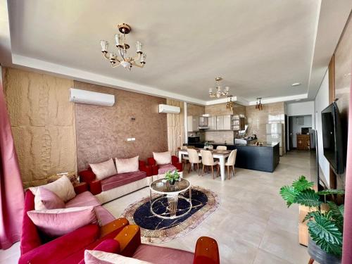 エル・アラメインにあるModern Furnished Apartment Mazarine North Coastの赤いソファとテーブルのあるリビングルーム
