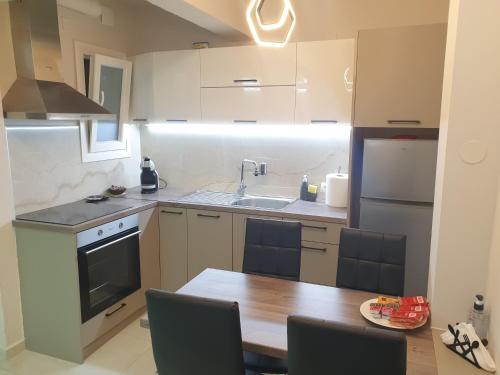 a small kitchen with a wooden table and a sink at BlackGeorge Apartment in Ioannina