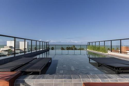 a balcony with benches on top of a building at Flats a 50m do mar Legacy Suites - MyFlats Hospedagens in Tambaú