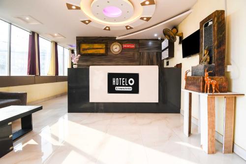 a living room with a clock on the wall at Hotel O Hirak Road Dhanbad in Dhanbād